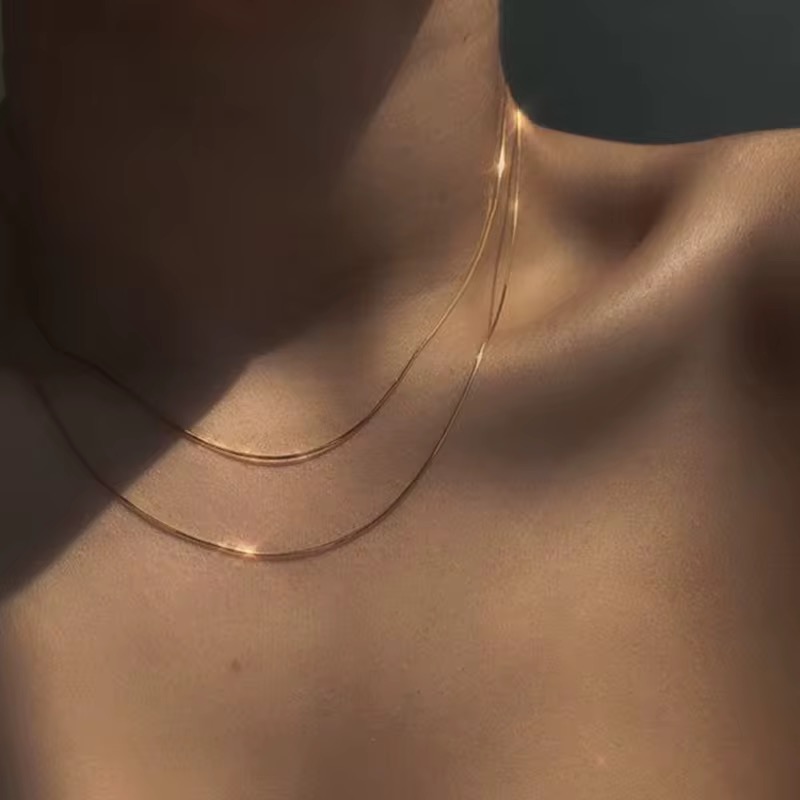 Layered gold chain necklaces on neckline